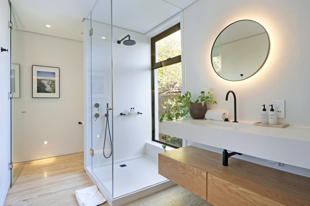 Glass shower, backlit mirror, black fixtures