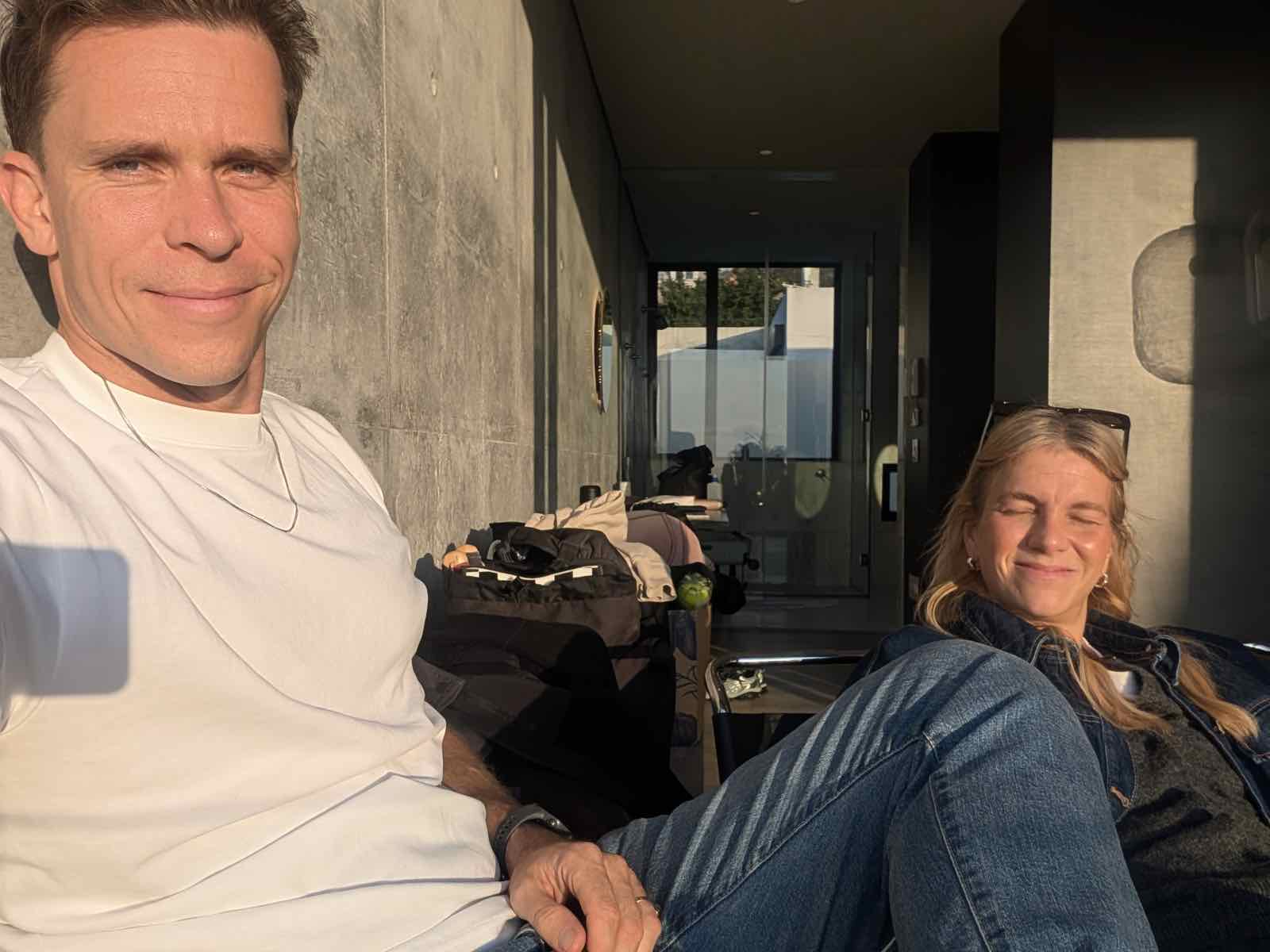 Kira and Phil sitting in the bare concrete interior of the house during construction